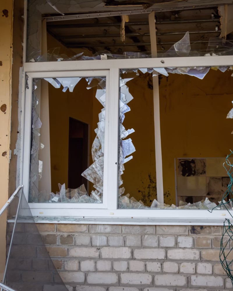 Glazier repairing a broken glass window in a residential property.