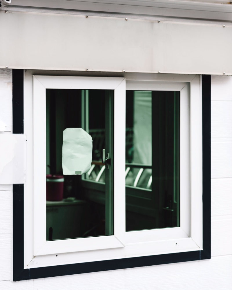 Glazier fitting replacement glass in a home window.